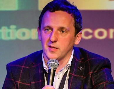 Roger Percy speaking on stage